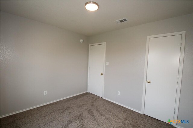 unfurnished bedroom featuring visible vents, carpet flooring, and baseboards