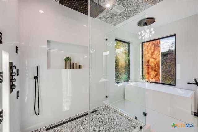 bathroom with tile patterned floors, a chandelier, and walk in shower