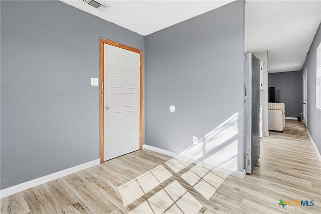 unfurnished room with light wood-type flooring