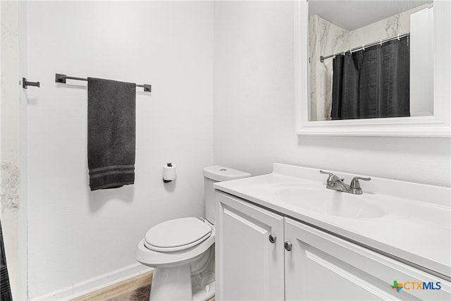 bathroom with hardwood / wood-style floors, curtained shower, vanity, and toilet