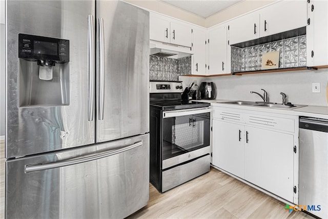 kitchen with light hardwood / wood-style floors, stainless steel appliances, white cabinets, a textured ceiling, and sink