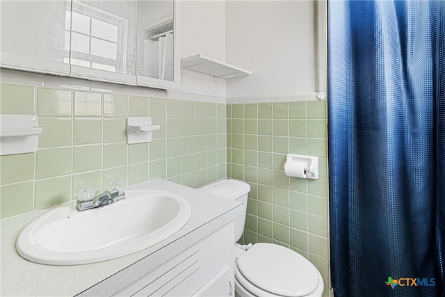 bathroom featuring tile walls, curtained shower, sink, and toilet