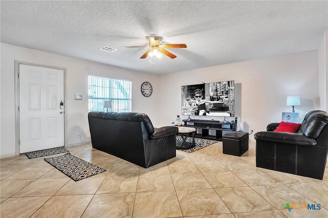 tiled living room featuring a textured ceiling and ceiling fan