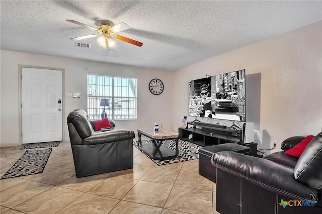 living room featuring light tile patterned floors, a textured ceiling, and ceiling fan