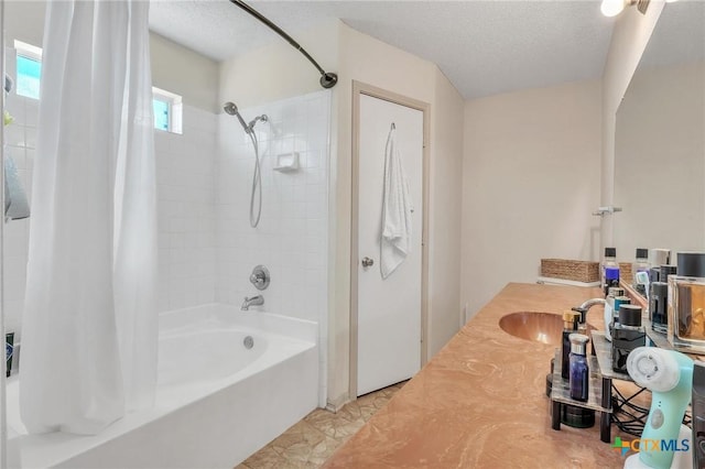 bathroom featuring a textured ceiling, vanity, and shower / tub combo