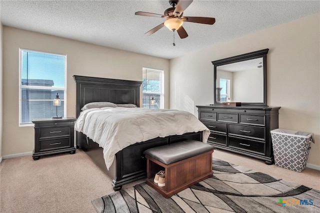 carpeted bedroom with ceiling fan and a textured ceiling