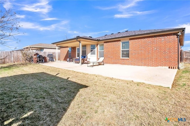 back of property featuring a patio area and a yard