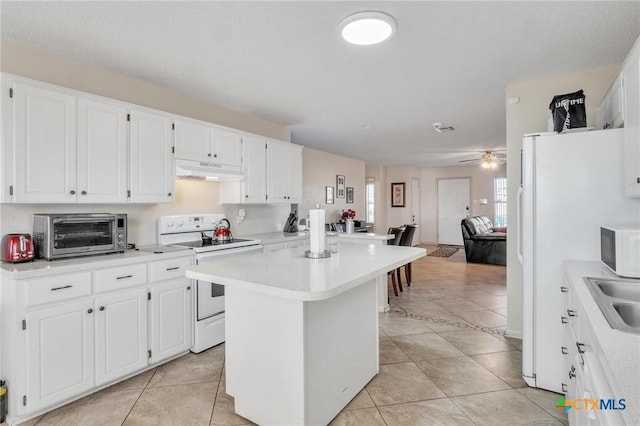 kitchen featuring a center island, white cabinets, white appliances, and light tile patterned floors