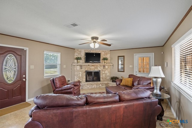 living area with a fireplace, a ceiling fan, baseboards, visible vents, and crown molding