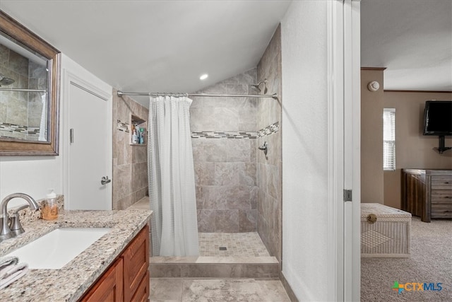 bathroom with a tile shower and vanity