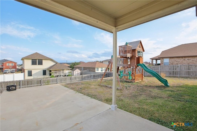 view of play area with a lawn and a patio area