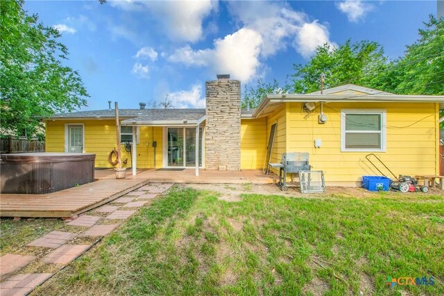 1109 Meadow Dr, Killeen, TX 76549 - back of property featuring a covered hot tub, a chimney, and a deck