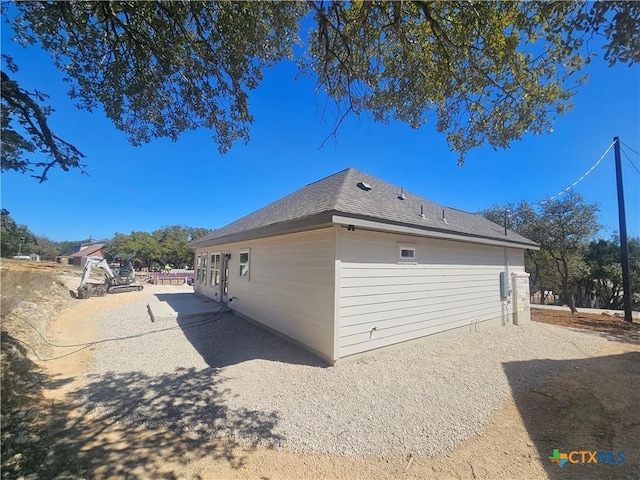 view of home's exterior with roof with shingles