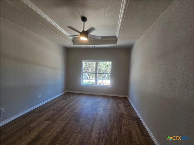 spare room with visible vents, baseboards, a raised ceiling, dark wood-style flooring, and a textured ceiling