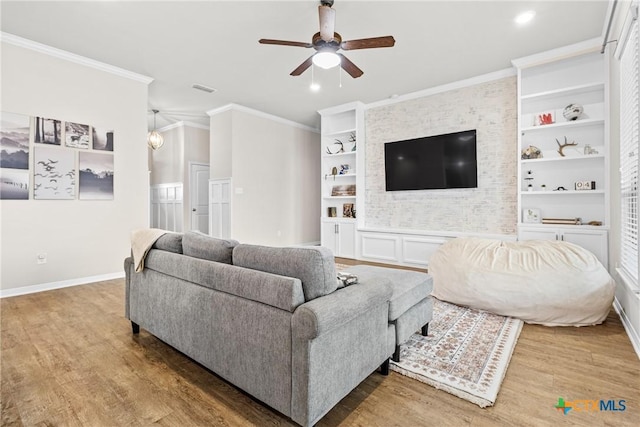 living area featuring crown molding, ceiling fan, baseboards, built in features, and wood finished floors