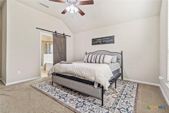 carpeted bedroom featuring visible vents, baseboards, a barn door, vaulted ceiling, and ensuite bath