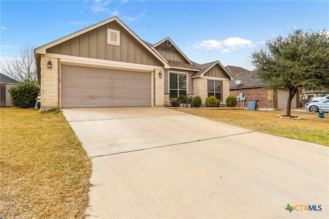 view of front facade featuring a front yard, concrete driveway, a garage, stone siding, and board and batten siding