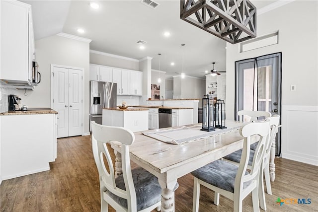 dining area with wood finished floors, visible vents, recessed lighting, ornamental molding, and wainscoting