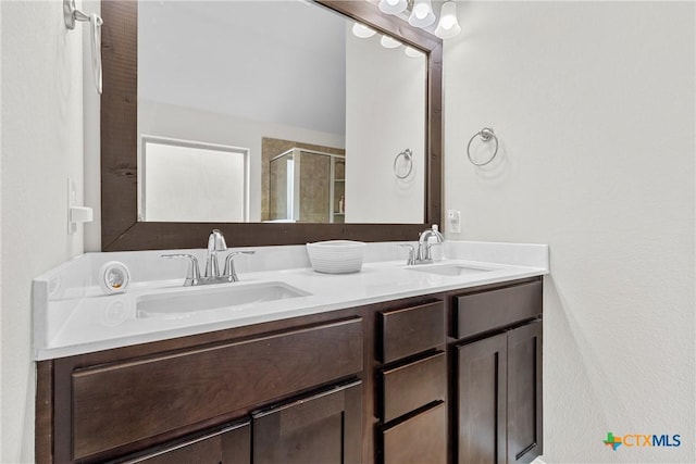 full bath with double vanity, a shower stall, and a sink