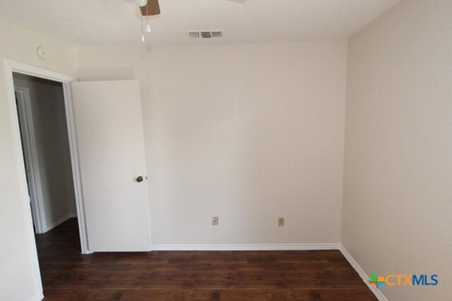 unfurnished room featuring baseboards, wood finished floors, and visible vents