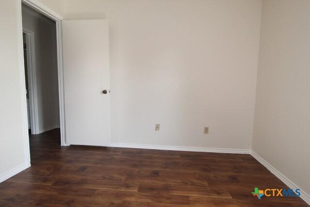 empty room with baseboards and wood finished floors