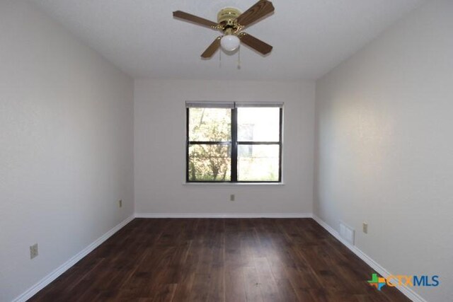 empty room featuring baseboards, ceiling fan, wood finished floors, and visible vents
