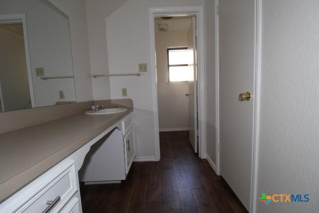 bathroom with wood-type flooring, baseboards, and vanity