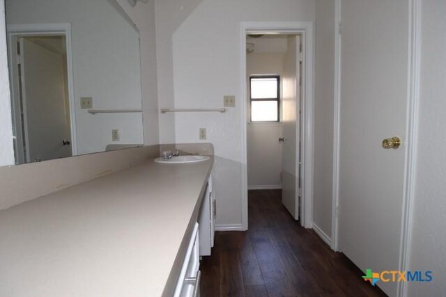 bathroom featuring baseboards, hardwood / wood-style flooring, and vanity