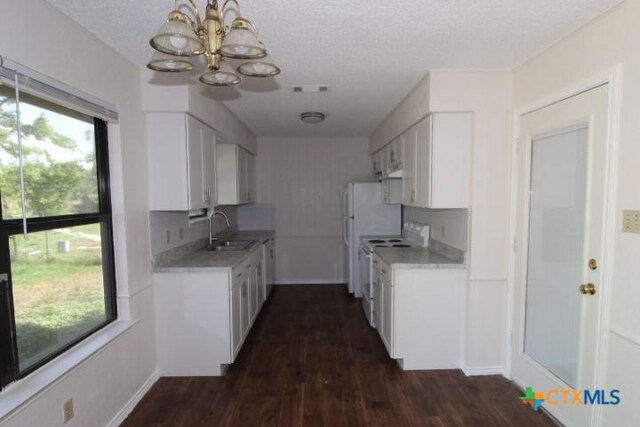 kitchen featuring a sink, white range with electric cooktop, an inviting chandelier, and a healthy amount of sunlight