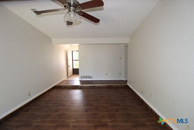 empty room featuring visible vents, a ceiling fan, baseboards, and wood finished floors