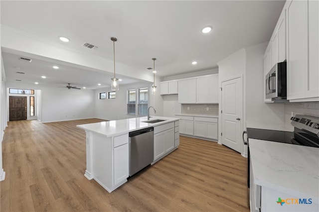 kitchen featuring a kitchen island with sink, white cabinets, sink, light hardwood / wood-style floors, and stainless steel appliances