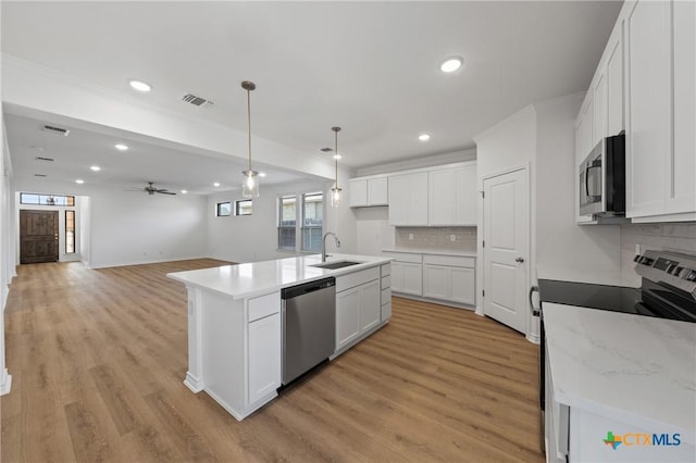 7310 Caladium Dr, Temple, TX 76502 - kitchen with appliances with stainless steel finishes, a sink, recessed lighting, tasteful backsplash, and open floor plan