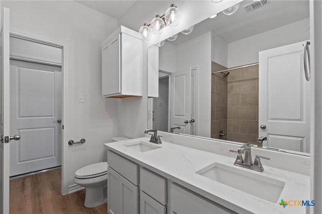 7310 Caladium Dr, Temple, TX 76502 - bathroom with toilet, wood finished floors, double vanity, and a shower