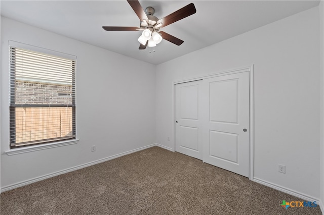 unfurnished bedroom featuring carpet floors, a closet, and ceiling fan