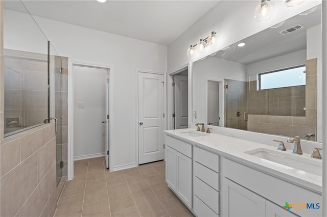 bathroom featuring a shower with door, vanity, and tile patterned flooring