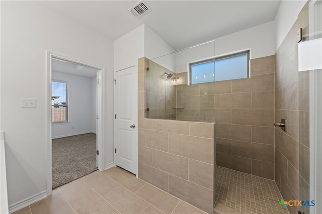 bathroom with tile patterned floors and a tile shower