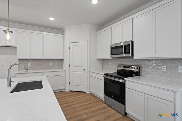 7310 Caladium Dr, Temple, TX 76502 - kitchen with appliances with stainless steel finishes, a sink, crown molding, backsplash, and light wood finished floors