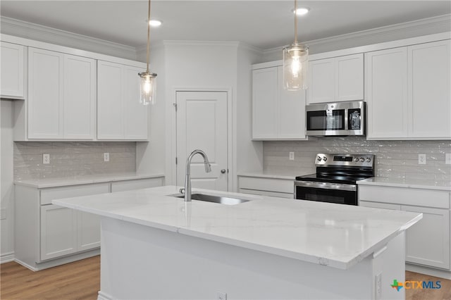 kitchen with decorative light fixtures, sink, white cabinetry, and stainless steel appliances