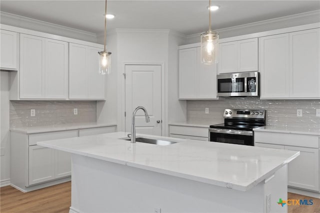 7310 Caladium Dr, Temple, TX 76502 - kitchen with appliances with stainless steel finishes, a sink, tasteful backsplash, a kitchen island with sink, and light wood-style flooring