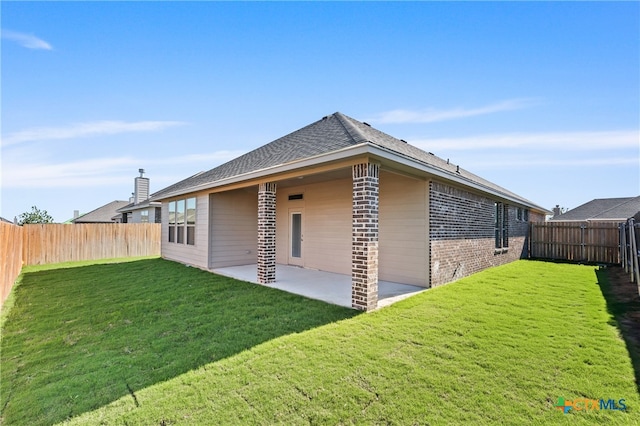 rear view of property featuring a yard and a patio