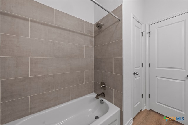 bathroom with hardwood / wood-style floors and tiled shower / bath