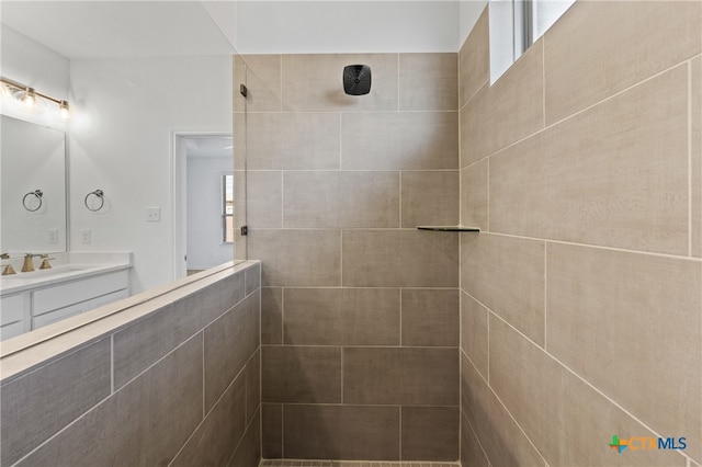 bathroom featuring vanity and tiled shower