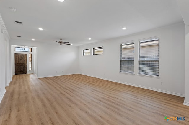 spare room featuring crown molding, ceiling fan, and light wood-type flooring