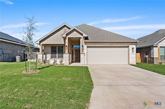 craftsman inspired home with central air condition unit, a front yard, and a garage