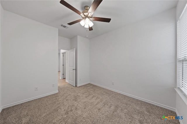 7310 Caladium Dr, Temple, TX 76502 - unfurnished bedroom with light colored carpet, baseboards, multiple windows, and ceiling fan