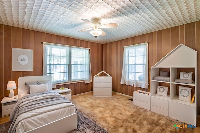 807 E 12th Ave, Belton, TX 76513 - carpeted bedroom featuring wood walls and a ceiling fan