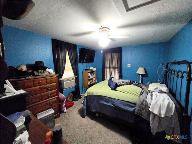 carpeted bedroom featuring cooling unit, ceiling fan, a textured wall, and a textured ceiling