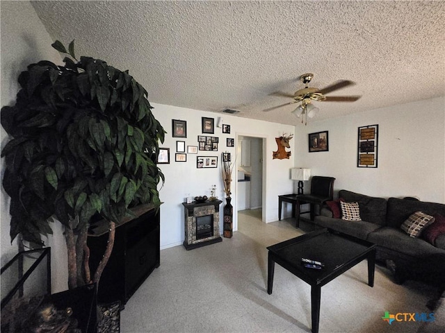 living area featuring a ceiling fan, a textured ceiling, baseboards, and visible vents