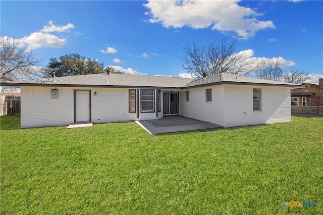 rear view of property featuring a yard and a patio area