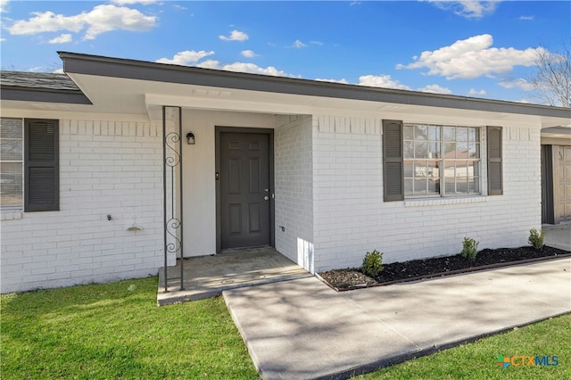 entrance to property featuring a yard